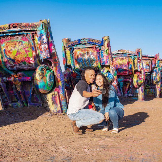 Posing near the colorful cars of Cadillac Ranch in Amarillo, Texas